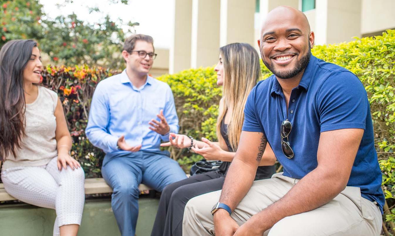 Four FAU Students smiling on campus